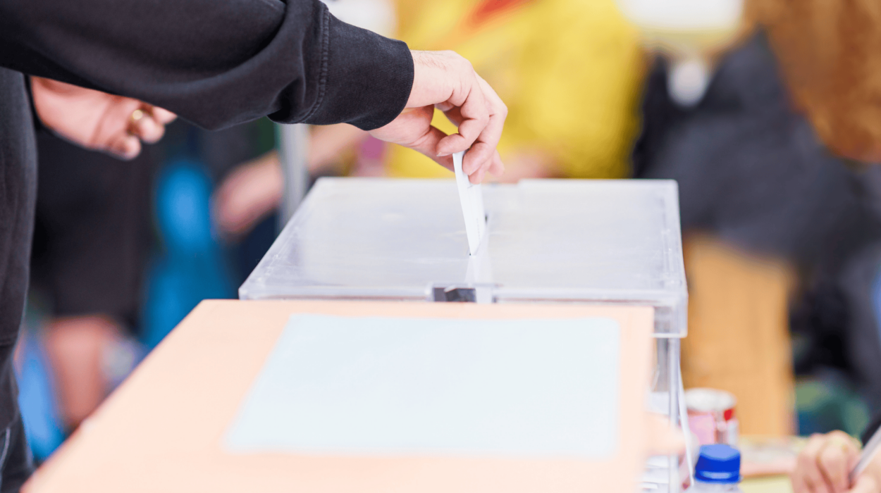 Darstellung eines Wählers der einen Wahlzettel in eine Wahlurne schmeißt.