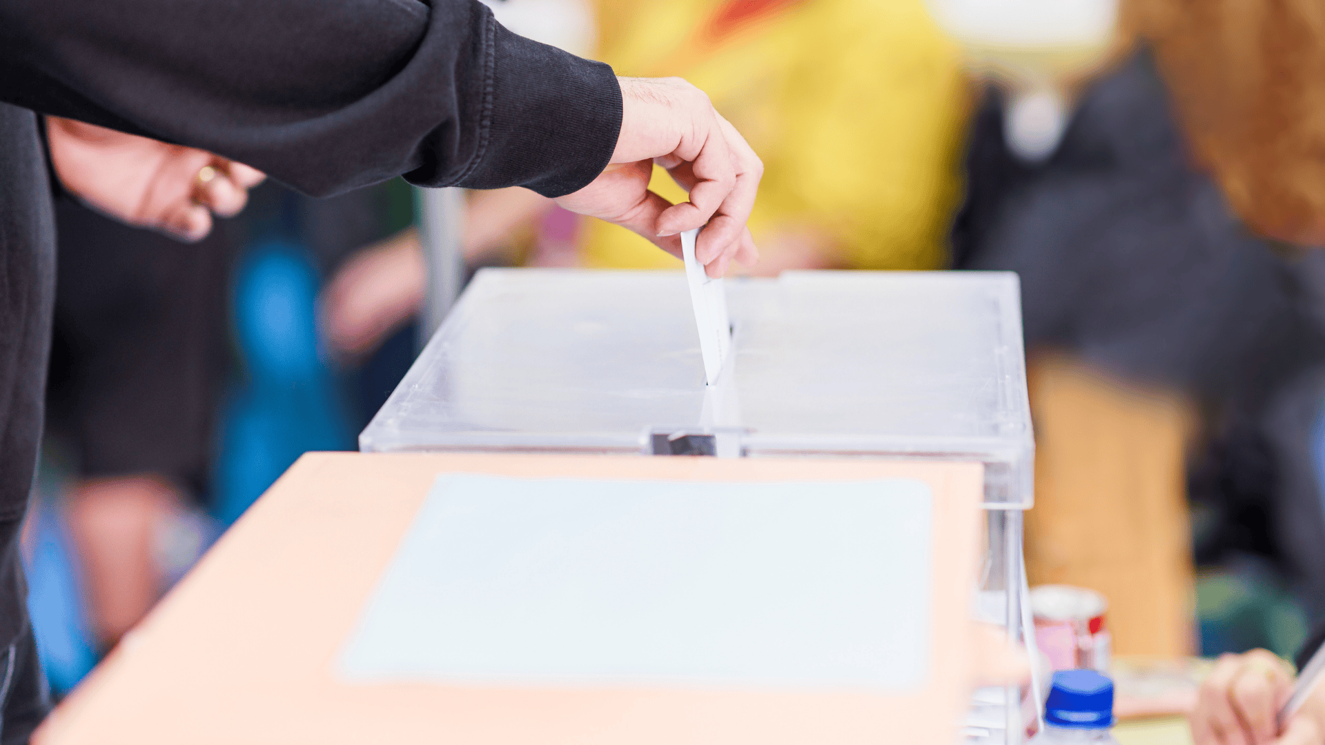 Darstellung eines Wählers der einen Wahlzettel in eine Wahlurne schmeißt.